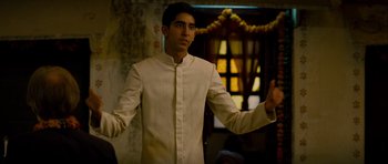 Movie still from “The Best Exotic Marigold Hotel” (2011), directed by John Madden – A man in a white shirt is holding his hands out; Medium shot, Low angle