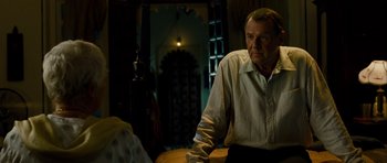 Movie still from “The Best Exotic Marigold Hotel” (2011), directed by John Madden – An older man standing in front of a table; Medium shot, Over the shoulder angle