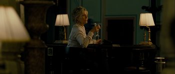 Movie still from “The Best Exotic Marigold Hotel” (2011), directed by John Madden – A woman sitting at a table holding a glass of wine; Medium shot, Over the shoulder angle