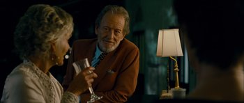 Movie still from “The Best Exotic Marigold Hotel” (2011), directed by John Madden – An older man holding a wine glass in his right hand; Close Up shot, Over the shoulder angle