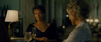 Movie still from “The Best Exotic Marigold Hotel” (2011), directed by John Madden – Two women sitting at a table with a glass of wine; Close Up shot, Over the shoulder angle