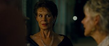 Movie still from “The Best Exotic Marigold Hotel” (2011), directed by John Madden – An older woman wearing a necklace and a black dress; Close Up shot, Over the shoulder angle