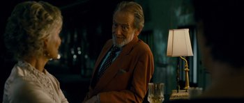 Movie still from “The Best Exotic Marigold Hotel” (2011), directed by John Madden – An older man sitting in front of a table with a glass of wine; Medium shot, Over the shoulder angle