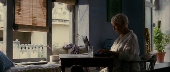 Movie still from “The Best Exotic Marigold Hotel” (2011), directed by John Madden – An older woman sitting in front of a laptop computer; Wide shot, Low angle