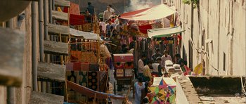 Movie still from “The Best Exotic Marigold Hotel” (2011), directed by John Madden – A group of people standing around a market with kites; Extreme Wide shot, High angle