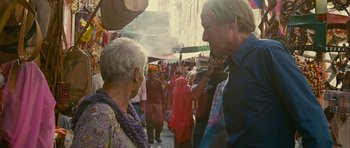 Movie still from “The Best Exotic Marigold Hotel” (2011), directed by John Madden – A man and a woman talking to each other in a crowded market place; Medium shot, Over the shoulder angle