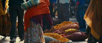 Movie still from “The Best Exotic Marigold Hotel” (2011), directed by John Madden – A woman standing in front of a pile of flowers; Extreme Close Up shot, High angle