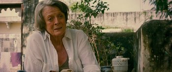 Movie still from “The Best Exotic Marigold Hotel” (2011), directed by John Madden – An older woman sitting at a table outside; Close Up shot, Over the shoulder angle