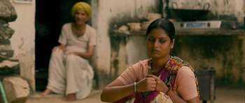 Movie still from “The Best Exotic Marigold Hotel” (2011), directed by John Madden – A woman sitting on the ground in front of another woman; Medium shot, Over the shoulder angle