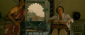 Movie still from “The Best Exotic Marigold Hotel” (2011), directed by John Madden – An old man sitting on a chair in front of an open window; Medium shot, Low angle