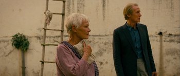 Movie still from “The Best Exotic Marigold Hotel” (2011), directed by John Madden – An older woman holding a blanket in her hands; Medium shot, Over the shoulder angle