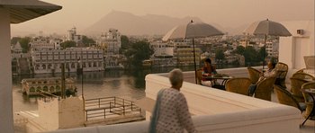 Movie still from “The Best Exotic Marigold Hotel” (2011), directed by John Madden – A woman sitting on a bench with an open umbrella; Extreme Wide shot, High angle