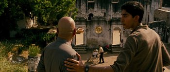 Movie still from “The Best Exotic Marigold Hotel” (2011), directed by John Madden – Two men standing next to each other in front of an old building; Medium shot, Over the shoulder angle