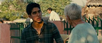 Movie still from “The Best Exotic Marigold Hotel” (2011), directed by John Madden – A man talking to an older man in a plaid shirt; Medium shot, Over the shoulder angle