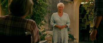 Movie still from “The Best Exotic Marigold Hotel” (2011), directed by John Madden – An older woman standing in front of some bushes; Medium shot, Low angle