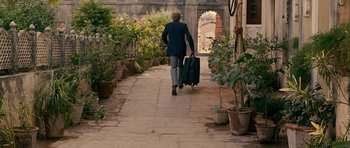 Movie still from “The Best Exotic Marigold Hotel” (2011), directed by John Madden – A woman walking down a path with a suitcase; Wide shot, Over the shoulder angle