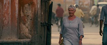 Movie still from “The Best Exotic Marigold Hotel” (2011), directed by John Madden – An older woman walking down the street holding a purse; Medium shot, Over the shoulder angle