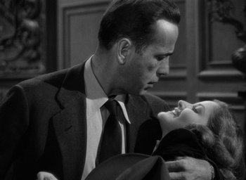 Movie still from “The Big Sleep” (1946), directed by Howard Hawks – A man and a woman embracing each other in a black and white photo; Close Up shot, Low angle