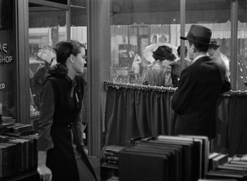 Movie still from “The Big Sleep” (1946), directed by Howard Hawks – A woman walking in front of a store window; Medium shot, Over the shoulder angle