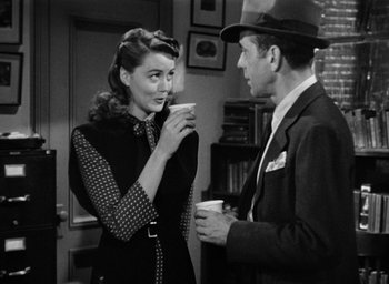 Movie still from “The Big Sleep” (1946), directed by Howard Hawks – A man and a woman are drinking coffee together; Medium shot, Over the shoulder angle