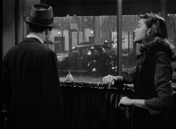 Movie still from “The Big Sleep” (1946), directed by Howard Hawks – A man and a woman standing in front of a window; Medium shot, Over the shoulder angle
