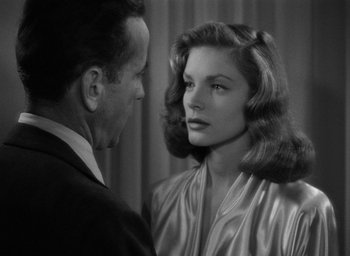 Movie still from “The Big Sleep” (1946), directed by Howard Hawks – A black and white photo of a man and a woman looking at each other; Close Up shot, Over the shoulder angle