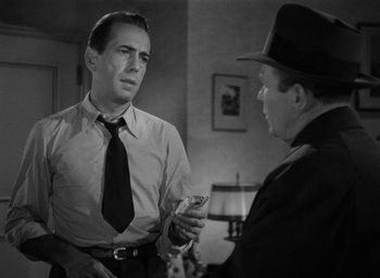 Movie still from “The Big Sleep” (1946), directed by Howard Hawks – A man in a suit and tie talking to another man in a suit and tie; Close Up shot, Over the shoulder angle