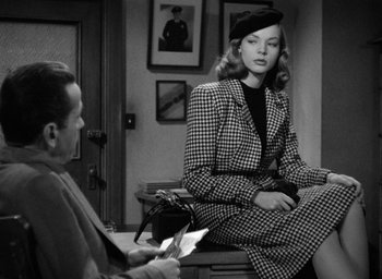 Movie still from “The Big Sleep” (1946), directed by Howard Hawks – A woman sitting on a chair in a room; Medium shot, Over the shoulder angle