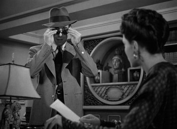 Movie still from “The Big Sleep” (1946), directed by Howard Hawks – A man in a suit and a woman in a hat; Medium shot, Over the shoulder angle