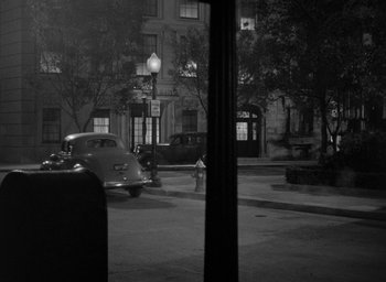 Movie still from “The Big Sleep” (1946), directed by Howard Hawks – An old car parked on the side of the street; Extreme Wide shot, High angle