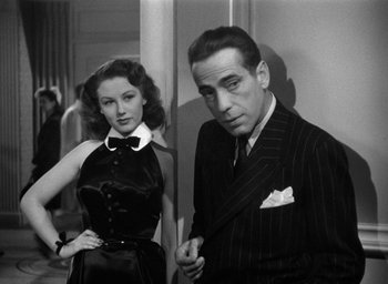 Movie still from “The Big Sleep” (1946), directed by Howard Hawks – A man and a woman standing next to each other; Medium shot, Low angle