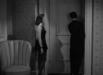 Movie still from “The Big Sleep” (1946), directed by Howard Hawks – A man and a woman standing in front of a door; Medium shot, Over the shoulder angle