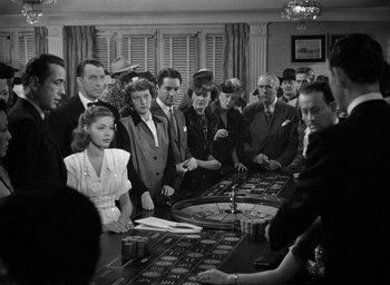Movie still from “The Big Sleep” (1946), directed by Howard Hawks – A black and white photo of people at a roulette table; Medium shot, High angle