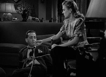 Movie still from “The Big Sleep” (1946), directed by Howard Hawks – A man and a woman sitting on a couch; Medium shot, High angle