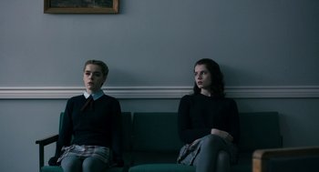 Movie still from “The Blackcoat's Daughter” (2015), directed by Oz Perkins – Two young people sitting on a couch in a room; Medium shot, Low angle