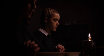 Movie still from “The Blackcoat's Daughter” (2015), directed by Oz Perkins – Two people sitting at a table with their hands clasped together; Close Up shot, Over the shoulder angle
