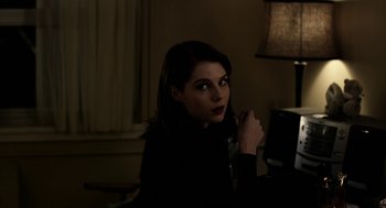 Movie still from “The Blackcoat's Daughter” (2015), directed by Oz Perkins – A woman with dark hair and a black jacket; Medium shot, Over the shoulder angle