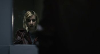 Movie still from “The Blackcoat's Daughter” (2015), directed by Oz Perkins – A woman looking at a computer screen in a dark room; Close Up shot, Low angle