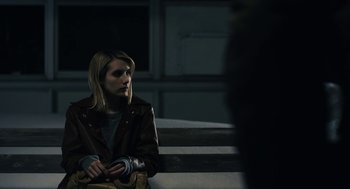 Movie still from “The Blackcoat's Daughter” (2015), directed by Oz Perkins – A woman sitting on steps in front of a building; Close Up shot, Over the shoulder angle