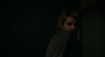 Movie still from “The Blackcoat's Daughter” (2015), directed by Oz Perkins – A woman standing in the dark with her hand on her shoulder; Close Up shot, Low angle