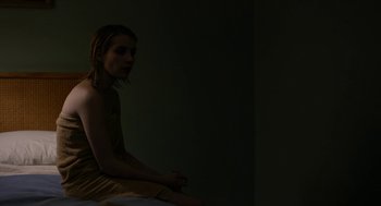 Movie still from “The Blackcoat's Daughter” (2015), directed by Oz Perkins – A woman sitting on a bed in a dark room; Medium shot, High angle
