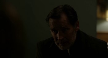 Movie still from “The Blackcoat's Daughter” (2015), directed by Oz Perkins – An older man in a black suit is looking at the camera; Close Up shot, High angle