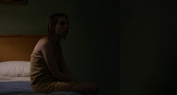 Movie still from “The Blackcoat's Daughter” (2015), directed by Oz Perkins – A woman sitting on top of a bed in the dark; Medium shot, High angle