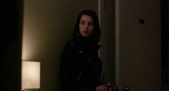 Movie still from “The Blackcoat's Daughter” (2015), directed by Oz Perkins – A woman in a black jacket standing next to a door; Close Up shot, Over the shoulder angle