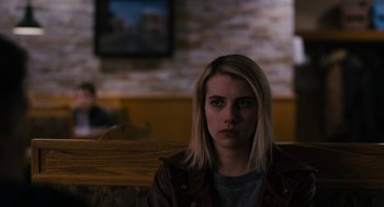 Movie still from “The Blackcoat's Daughter” (2015), directed by Oz Perkins – A woman sitting at a table in front of a television; Close Up shot, Over the shoulder angle