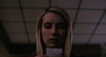 Movie still from “The Blackcoat's Daughter” (2015), directed by Oz Perkins – A woman holding a piece of paper in front of her face; Close Up shot, Low angle