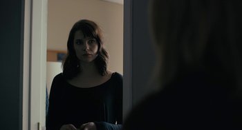 Movie still from “The Blackcoat's Daughter” (2015), directed by Oz Perkins – A woman standing in front of a bathroom mirror; Close Up shot, Over the shoulder angle