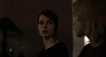 Movie still from “The Blackcoat's Daughter” (2015), directed by Oz Perkins – A woman standing next to another woman in front of a wall; Close Up shot, Over the shoulder angle