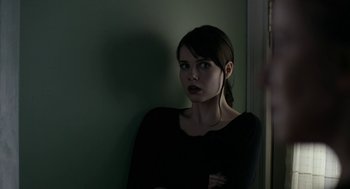 Movie still from “The Blackcoat's Daughter” (2015), directed by Oz Perkins – A woman standing in front of a green wall; Close Up shot, Over the shoulder angle