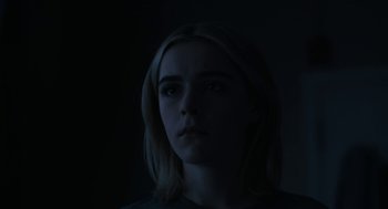 Movie still from “The Blackcoat's Daughter” (2015), directed by Oz Perkins – A woman is looking at the camera in the dark; Close Up shot, Low angle